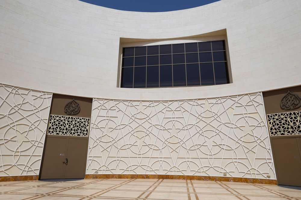Courtyard doors set into hand-cast geometric relief